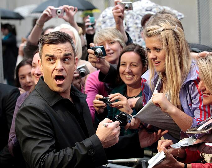 Weltstar im Fan-Gewusel: Robbie Williams verteilte Autogramme vor dem Mathäser-Kino.