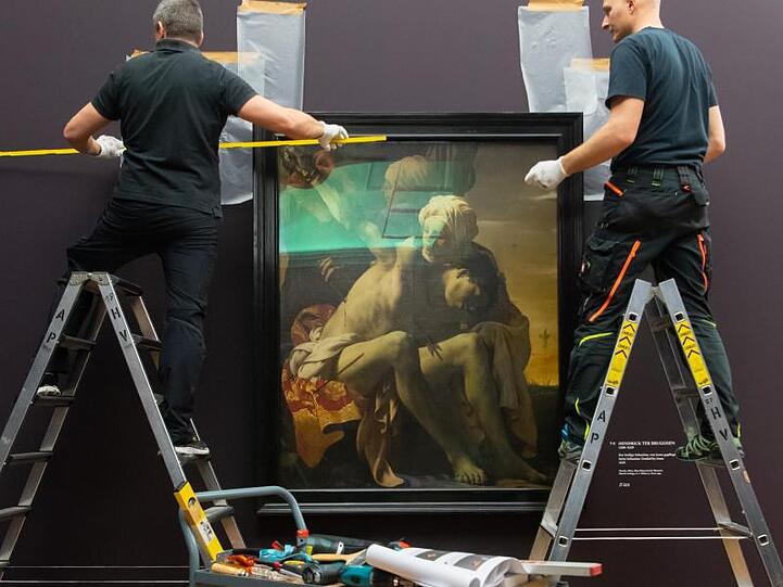 Museumsmitarbeiter hängen in der Alten Pinakothek das Bild "Der heilige Sebastian" von Hendrick ter Brugghen auf. Foto: Sven Hoppe/Archiv