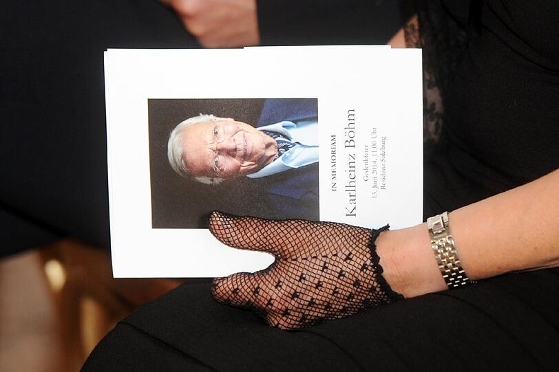 Eine Frau hält ein Programmheft mit dem Porträt von Karlheinz Böhm.