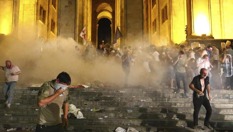 Demonstranten fliehen vor dem georgischen Parlament vor von Polizisten abgefeuertem Tränengas. Demonstranten fliehen vor dem georgischen Parlament vor von Polizisten abgefeuertem Tränengas.