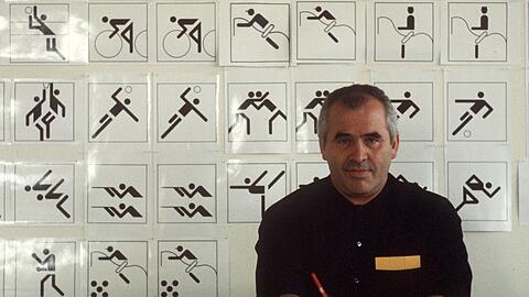 Der Grafikdesigner Otl Aicher vor einigen seiner zu den Olympischen Spielen entworfenen Piktogrammen.