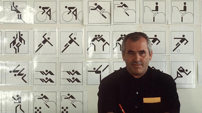 Der Grafikdesigner Otl Aicher vor einigen seiner zu den Olympischen Spielen entworfenen Piktogrammen.