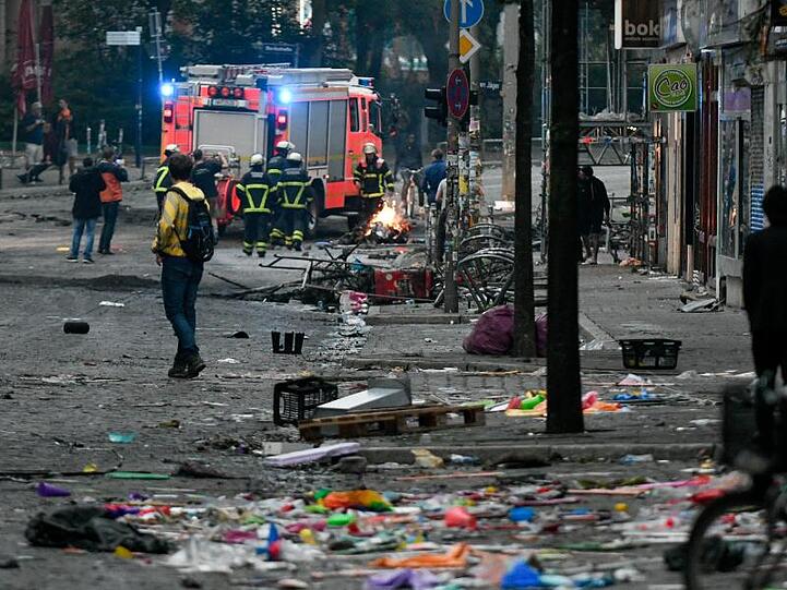 Feuerwehrleute löschen nach den eskalierten Protesten gegen den G20-Gipfel in Hamburg die letzten Brände.