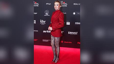 Helena Zengel in ihrem roten Komplett-Look mit schwarzer Spitzenstrumpfhose.