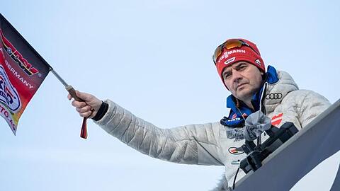 Stefan Horngacher, Bundestrainer der deutschen Skispringer, schwenkt beim Training eine Fahne. Foto: Daniel Karmann/dpa