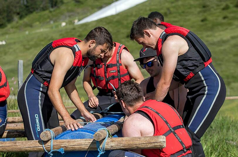Da war noch alles gut: Bei einer Teambuilding-Challenge bauen Neuzugang Coke (l) und seine Mannschaftskollegen an einem Floß.