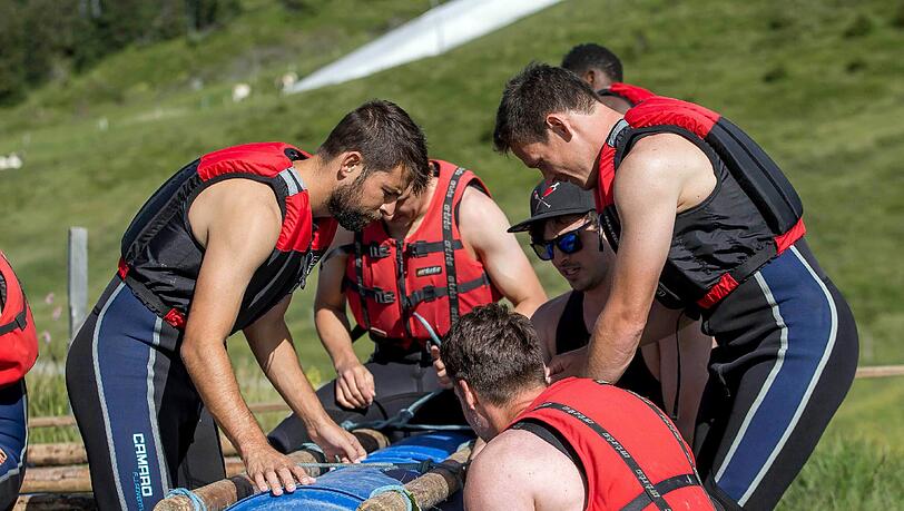 Da war noch alles gut: Bei einer Teambuilding-Challenge bauen Neuzugang Coke (l) und seine Mannschaftskollegen an einem Floß.