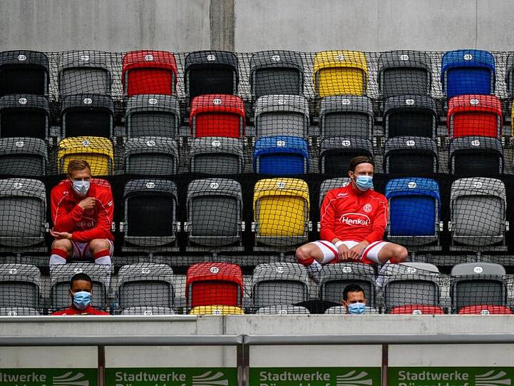 Spieler von Fortuna Düsseldorf sitzen auf der Tribüne.