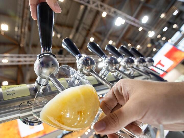 Ein Mitabreiter eines Stands auf der Getränkemesse "BrauBeviale" zapft ein Bier. Foto: Daniel Karmann/dpa/Archivbild