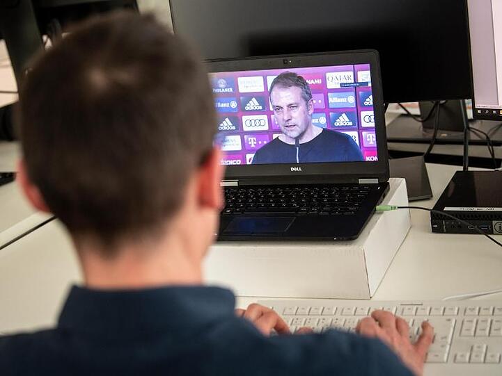 Ein Journalist verfolgt auf einem Laptop eine Video-Konferenz mit Hansi Flick vom FC Bayern München. Foto: Matthias Balk/dpa