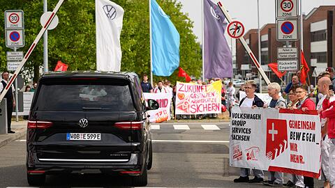 Ein VW-Bus mit VW-Vorstandschef Oliver Blume passiert die Demonstration von Beschäftigten am Werkstor des Standortes Zwickau. Ein VW-Bus mit VW-Vorstandschef Oliver Blume passiert die Demonstration von Beschäftigten am Werkstor des Standortes Zwickau.