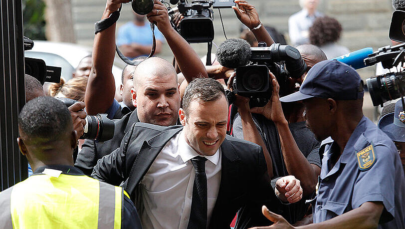 Bedrängt von Schaulustigen und Journalisten: Oscar Pistorius auf dem Weg ins Gericht in Pretoria. Bedrängt von Schaulustigen und Journalisten: Oscar Pistorius auf dem Weg ins Gericht in Pretoria.