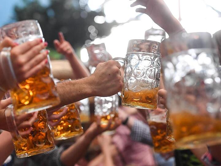 Wiesn-Besucher prosten sich gegenseitig zu. Foto: Tobias Hase/Archivbild