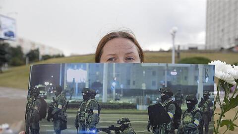 Bei einer Demonstration in Minsk präsentiert eine Frau ein Foto der gegen die Protestbewegung eingesetzten Sicherheitskräfte.