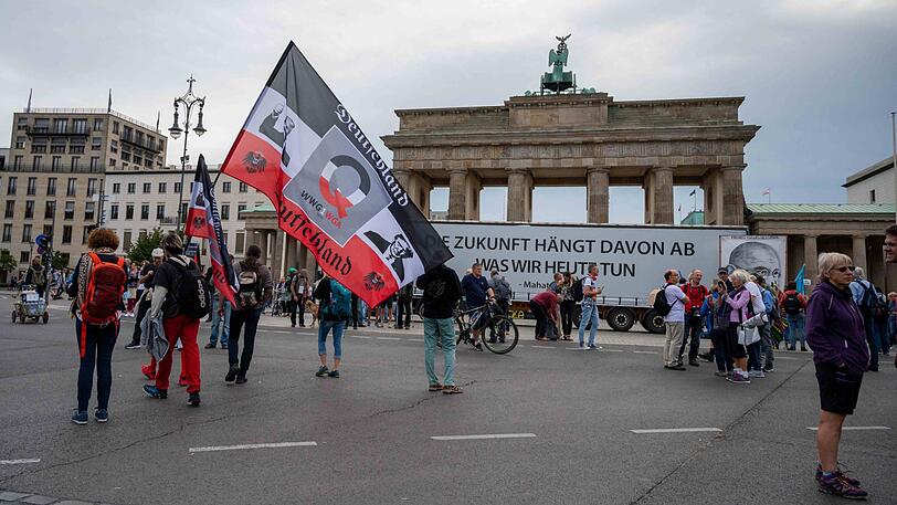 Ein Demonstrant hält vor der umstrittenen Demonstration gegen die Corona-Maßnahmen eine große Reichsflagge vor dem Brandenburger Tor.