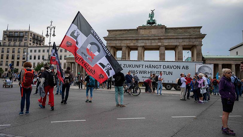 Ein Demonstrant hält vor der umstrittenen Demonstration gegen die Corona-Maßnahmen eine große Reichsflagge vor dem Brandenburger Tor.