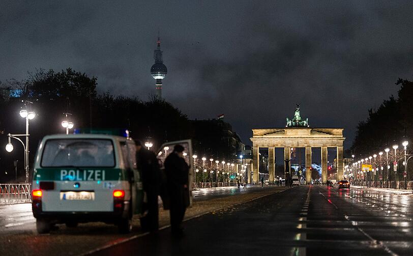 Polizisten stehen vor dem Brandenburger Tor auf einer leeren Straße, die anlässlich des Besuchs von US-Präsident Obama abgesperrt ist. Die eigens eingerichtete Sicherheitszone umfasst den gesamten Bereich um das Kanzleramt, den Reichstag, das Brandenburger Tor, die amerikanische Botschaft, das Hotel Adlon und das Holocaust-Mahnmal.
