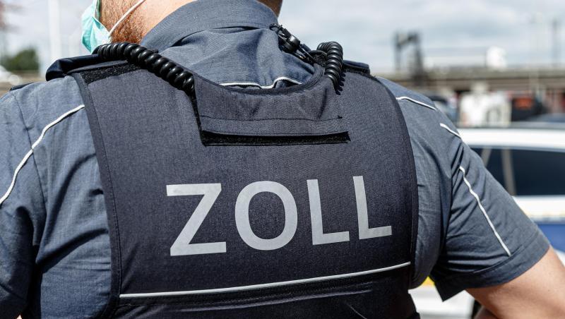 Ein Beamter trägt während seines Dienstes eine Schutzweste mit der Rückenaufschrift "Zoll". Foto: Markus Scholz/dpa/Symbolbild