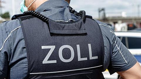 Ein Beamter trägt während seines Dienstes eine Schutzweste mit der Rückenaufschrift "Zoll". Foto: Markus Scholz/dpa/Symbolbild