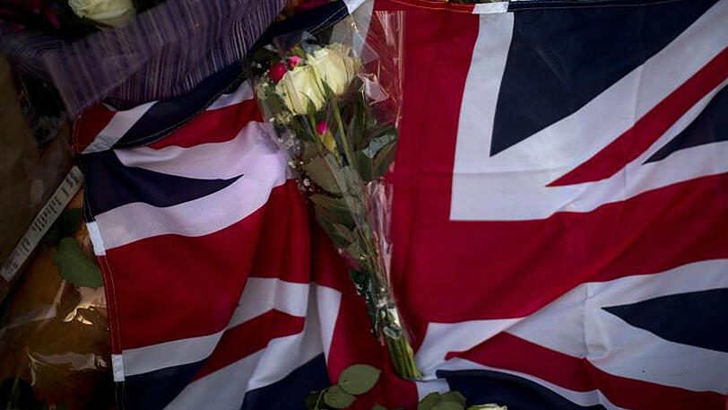 Ein Union Jack, Blumen und Kerzen liegen in Manchester nach einer Gedenkfeier auf dem Albert Square.