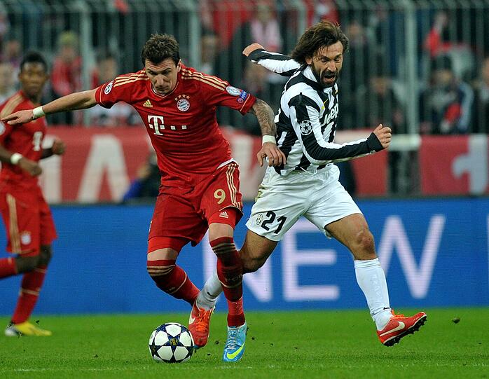 Bayerns Mario Mandzukic (l.) ist ein echter Torjäger, aber er ist noch viel mehr. Er ist als Stürmer auch der erste Verteidiger, stört das gegnerische Spiel - wie hier gegen Juventus-Star Andrea Pirlo.