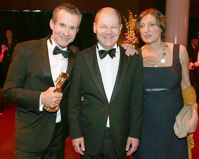 Der Schauspieler Ulrich Matthes (l-r), Hamburgs Bürgermeister Olaf Scholz (SPD) und seine Frau Britta Ernst posieren am 27.02.2015 nach der 50. Verleihung der Goldenen Kamera in den Messehallen in Hamburg bei der Dinner Party.