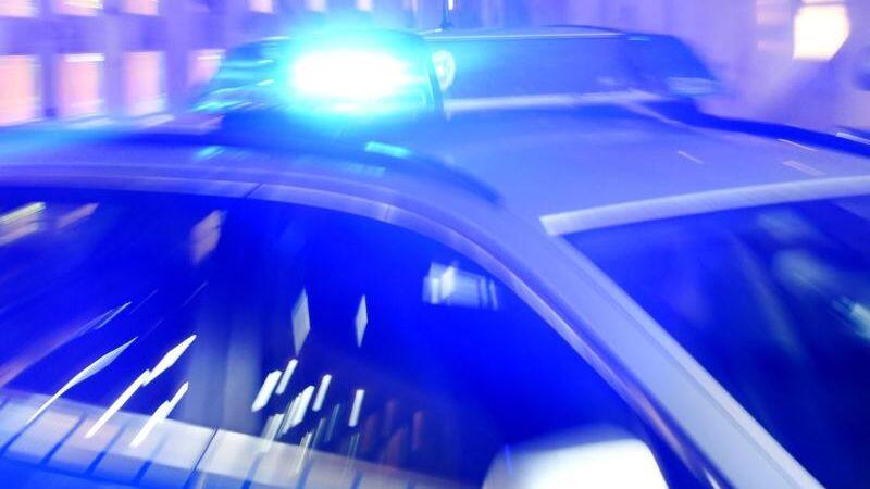 Ein Streifenwagen der Polizei steht mit eingeschaltetem Blaulicht auf der Straße. F. Foto: Carsten Rehder/dpa