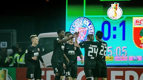 Augsburgs Spieler feiern den Treffer zum 1:0 gegen Holstein Kiel.