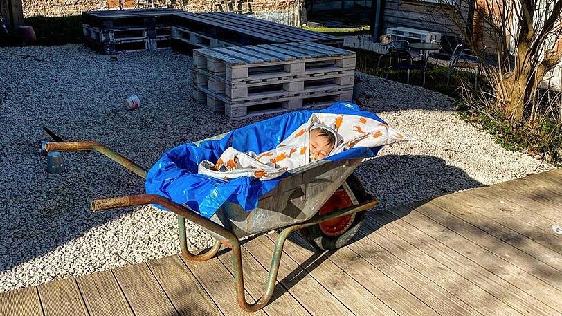 Sila Sahins Sohn Noah schlummert im Schubkarren in der Sonne.