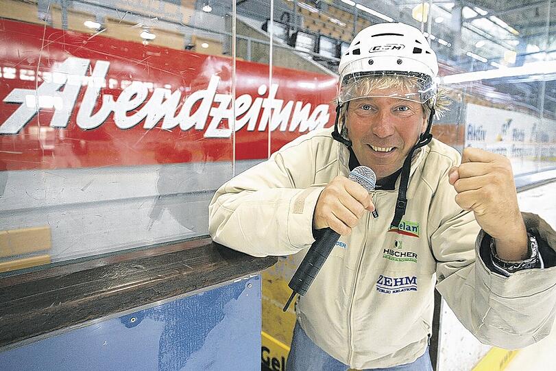 &bdquo;Eine Institution im Münchner Eishockey&ldquo;: Stadionsprecher Stefan Schneider vor der Abendzeitungs-Banderole im Olympia-Eisstadion. Foto: Mike Schmalz