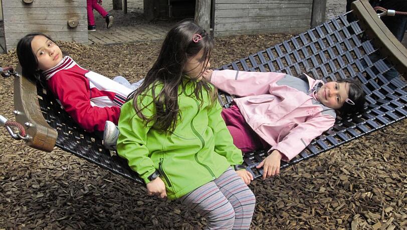 Drei Mädchen auf der Hängematte auf dem Neuaubinger Spielplatz. Drei Mädchen auf der Hängematte auf dem Neuaubinger Spielplatz.