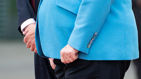 Angela Merkel presst die Hände zusammen, während ihre Beine zittern