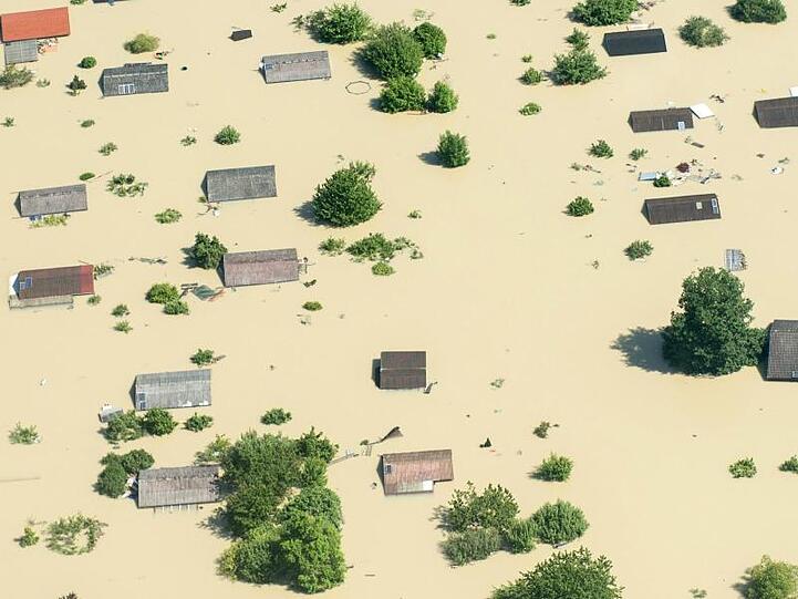 Dächer ragen im Juni 2013 nahe Deggendorf (Bayern) nach einem Dammbruch aus dem Hochwasser der Donau.