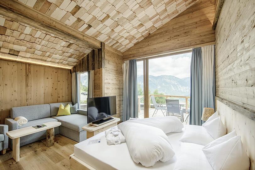 Das Naturdesign des Hotels beeindruckt mit natürlichen Materialien wie Naturstein und viel Zirbenholz.
In den Sky Chalets (hier im Bild) genießt man einen herrlichen Ausblick über das Dachsteinmassiv.