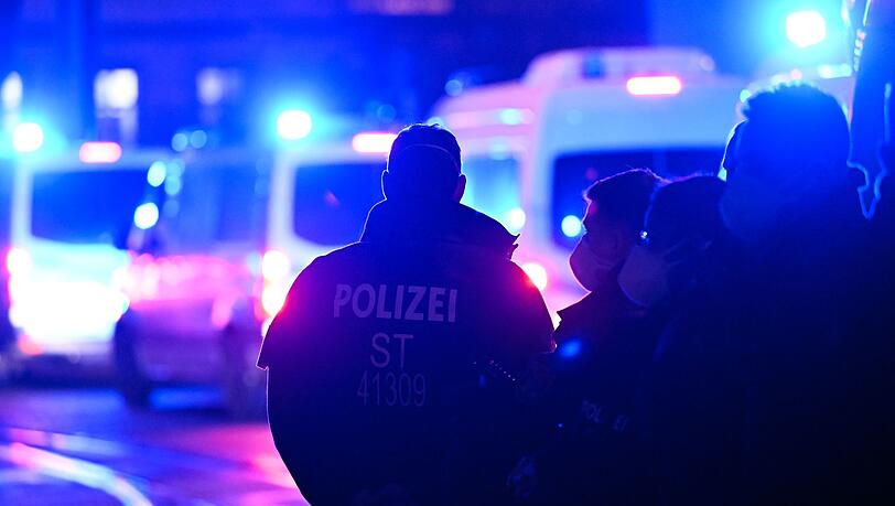 Polizisten stehen bei einem Einsatz auf der Straße. (Symbolbild)