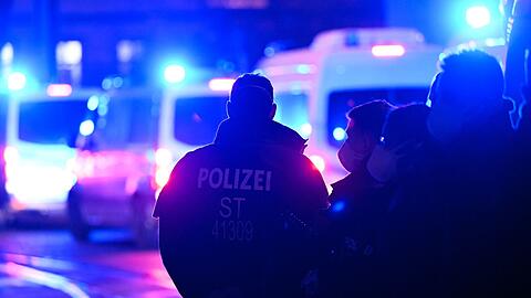Polizisten stehen bei einem Einsatz auf der Straße. (Symbolbild)