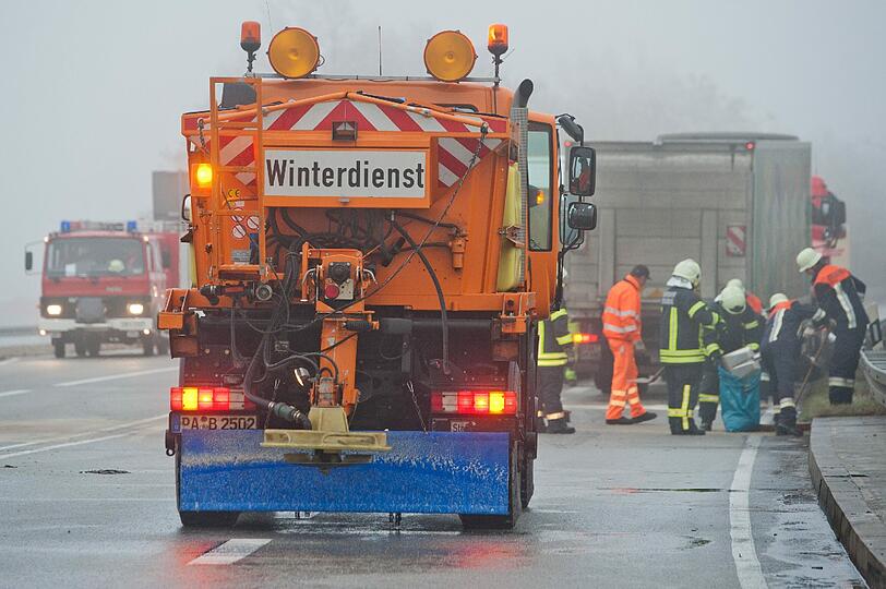 Ein Fahrzeug vom Winterdienst steht am Freitag (25.11.2011) auf der Bundesstraße 20 nahe Aiterhofen (Niederbayern) vor einer Unfallstelle. Laut Polizei waren an dem Glatteisunfall insgesamt vier Lastwagen und drei Autos beteiligt, mehrere Personen wurden verletzt.
