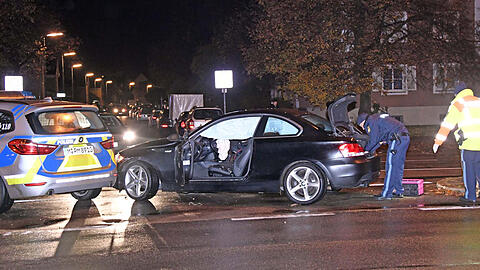 Polizisten sichern Spuren an dem BWM des Unfallfahrers.