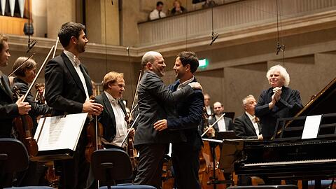 Im Herkulessaal umarmt der Komponist Francisco Coll den Pianisten Kirill Gerstein, der eben sein Klavierkonzert uraufgef&uuml;hrt hat. Dirigent Simon Rattle goutiert&rsquo;s.