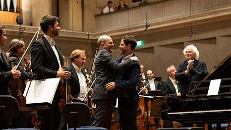 Im Herkulessaal umarmt der Komponist Francisco Coll den Pianisten Kirill Gerstein, der eben sein Klavierkonzert uraufgef&uuml;hrt hat. Dirigent Simon Rattle goutiert&rsquo;s.