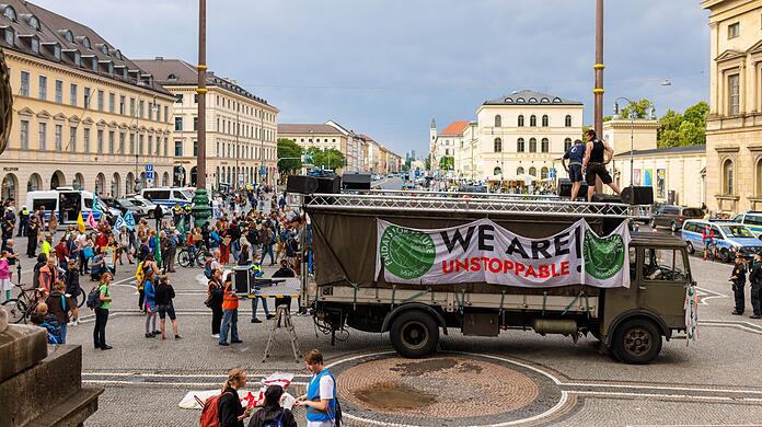 Teilnehmer einer Demonstration von Fridays for Future stehen neben einem LKW auf dem Odeonsplatz.