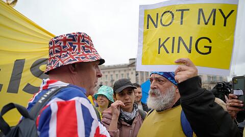 Ein Anti-Monarchie-Demonstrant (r) spricht mit einem Monarchie-Befürworter in der Nähe des Buckingham-Palastes.