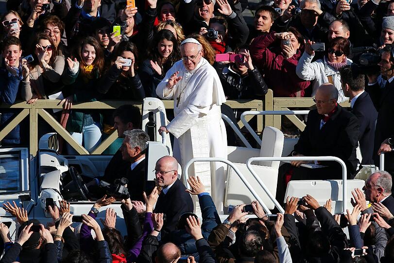 Der Papst winkt auf dem Petersplatz in die Menge.