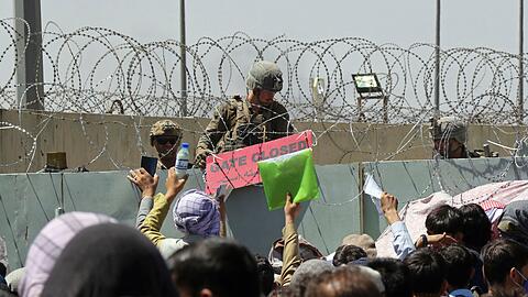 Hunderte von Menschen versammeln sich am 15.08.2022 nahe eines Evakuierungskontrollpunkts am Flughafen in Kabul, um aus dem Land zu fliehen.