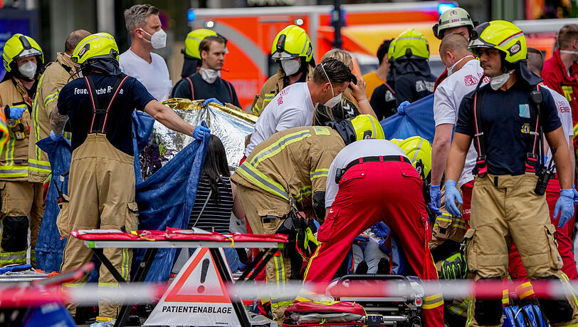 Rettungskräfte helfen einem Verletzten, nachdem ein Auto in eine Menschenmenge gefahren ist.