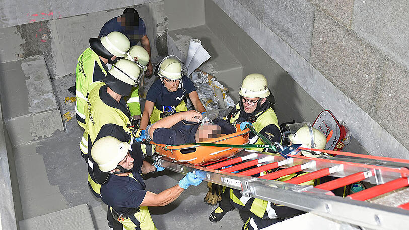 Die Feuerwehr rettet den Schwerverletzten aus der Grube.