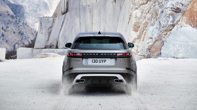 Schmale hintere Leuchten, dicke Auspuffrohre und ein Dachkantenspoiler: In der Heckansicht wirkt der Velar äußerst sportlich.