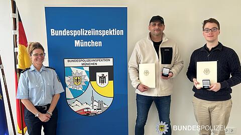 Die beiden geehrten Helfer. Links im Bild die stellvertretende Leiterin der Bundespolizeiinspektion M&uuml;nchen, Polizeidirektorin Sabine M&auml;der.