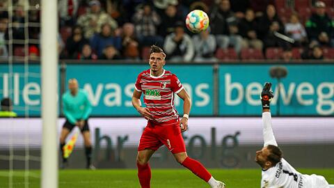 Augsburgs Ermedin Demirovic (M) zielt aufs Tor von Hoffenheims Oliver Baumann.