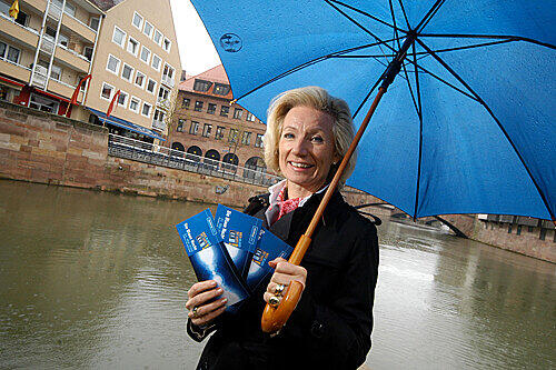Macht gute Mine zum bösen Wetter: Kulturreferentin Julia Lehner. Die Flyer-Präsentation unter einem Sonnenschirm gab sie auf Drängen der Fotografen bald auf.